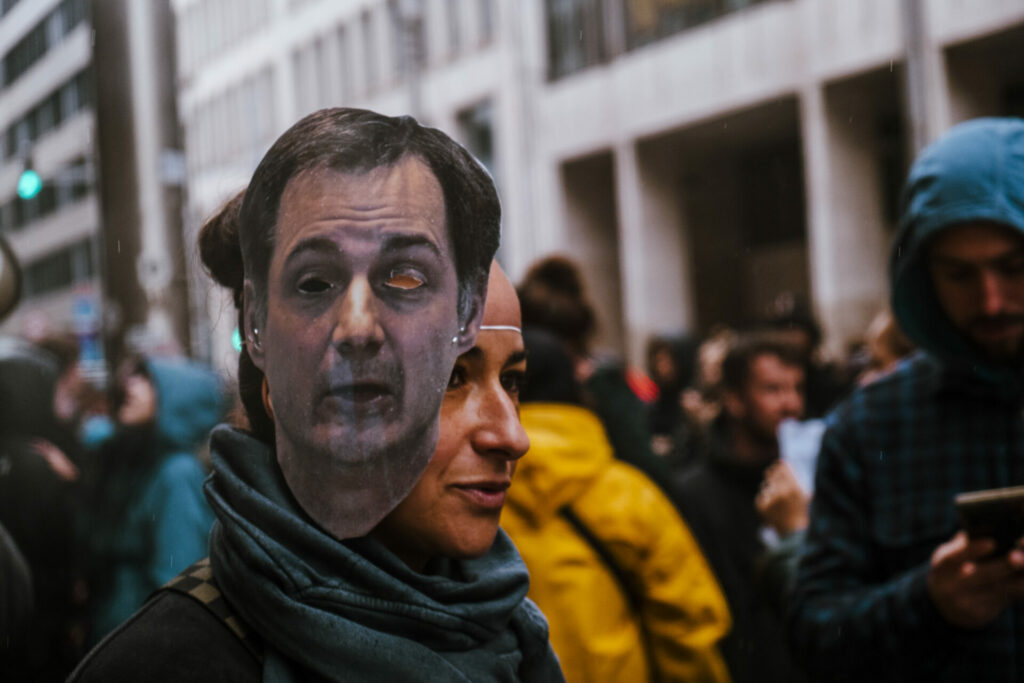 Activists with masks of Belgian politicians open up disused building for asylum seekers