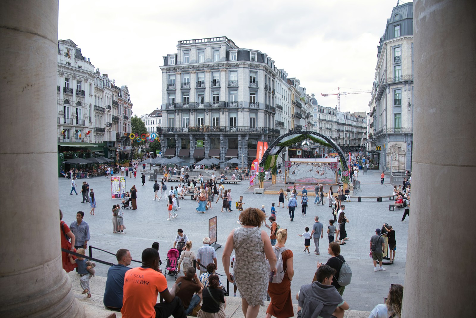 A crowd of people walking around a city square
