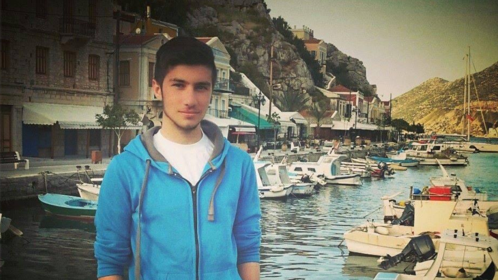 Young man standing in front of small port. 