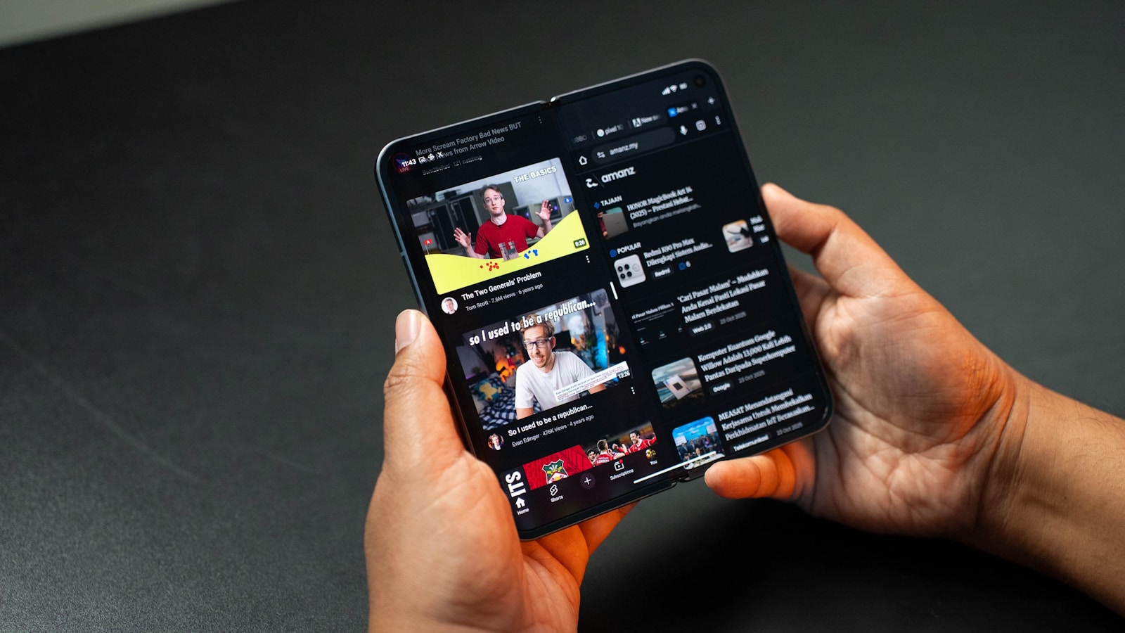 Hands holding a folding smartphone displaying youtube