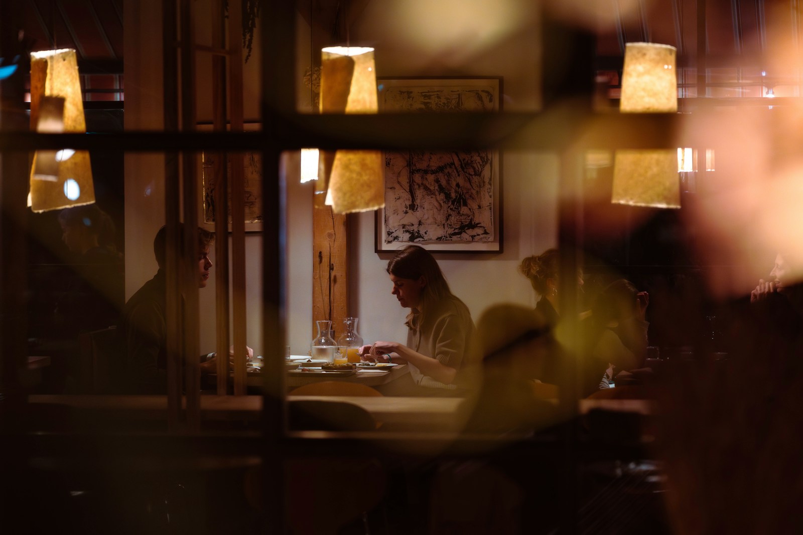 People dining at tables in a dimly lit restaurant. Dating