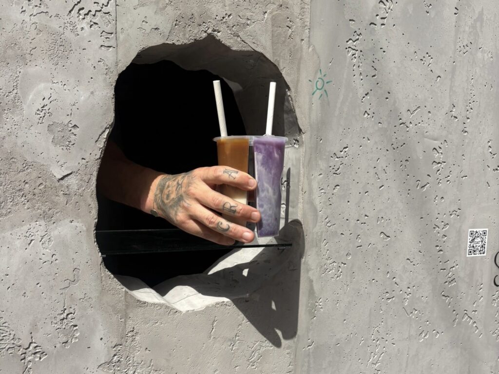 The faceless man selling coffee through a literal hole in a wall in Brussels