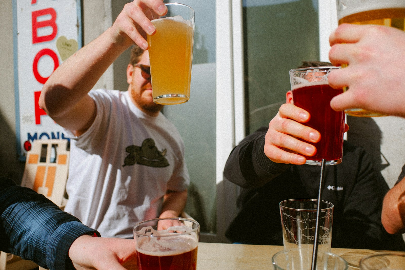 People are toasting with colorful glasses of beer